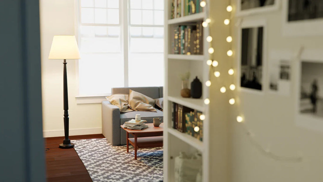 Cozy living room with gray sofa, wooden coffee table, floor lamp, patterned rug, and bookshelf with string lights