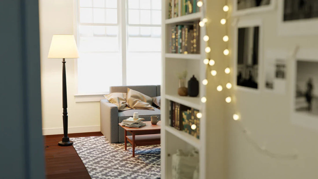 Cozy living room with gray sofa, wooden coffee table, floor lamp, patterned rug, and bookshelf with string lights